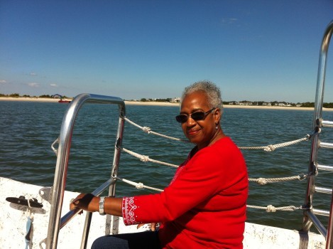 Woman on a boat off the coast with beach in the background