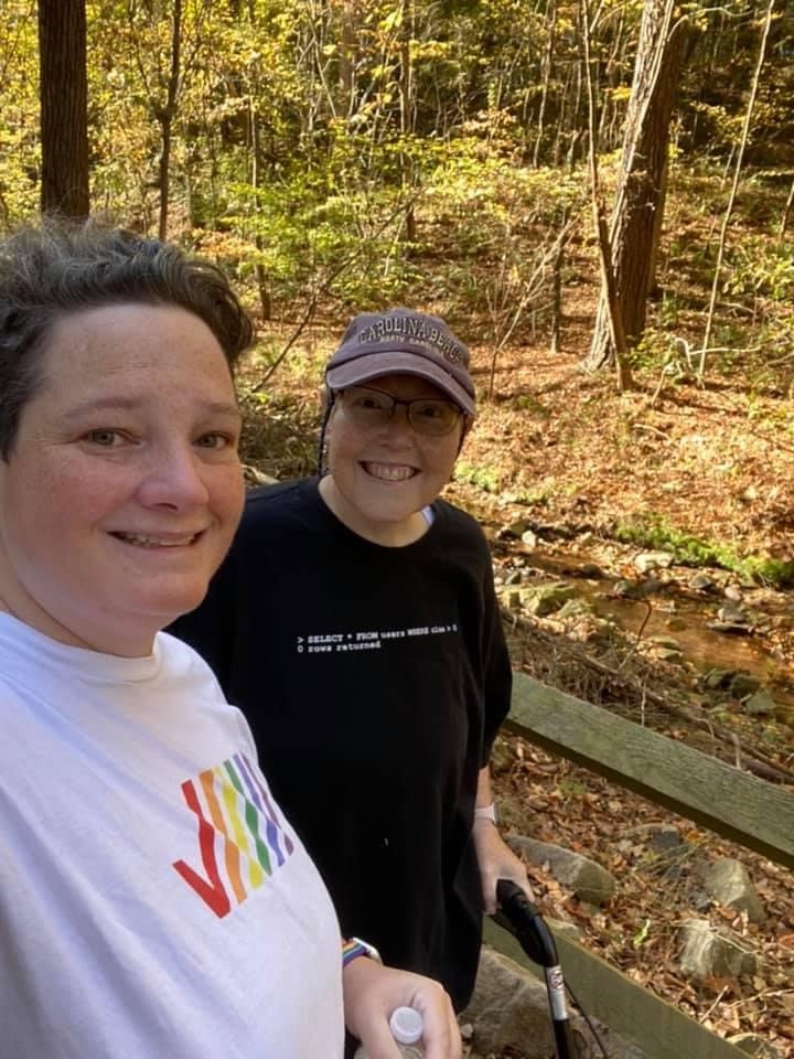 Two women smiling with woods in the background